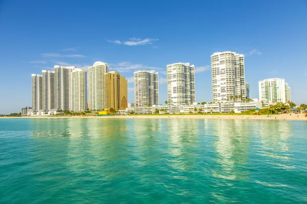 Bella spiaggia con preservativi e grattacielo nelle Isole Soleggiate — Foto Stock