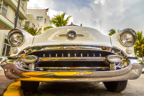 Classic Oldsmobile with chrome radiator grill parked in front o — Stock Photo, Image