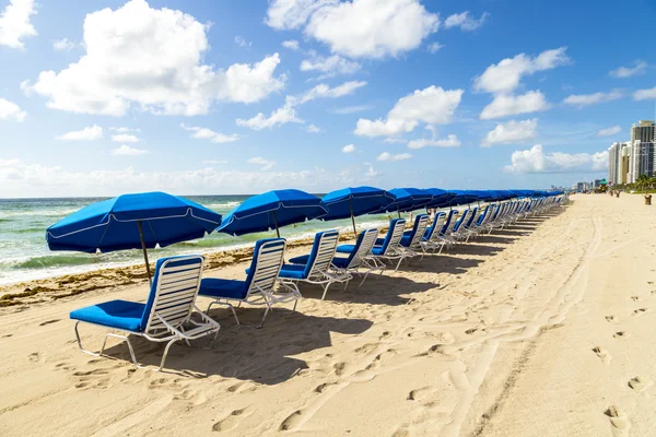 Umbrellas and empty beach couches at the beach — Stock Photo, Image