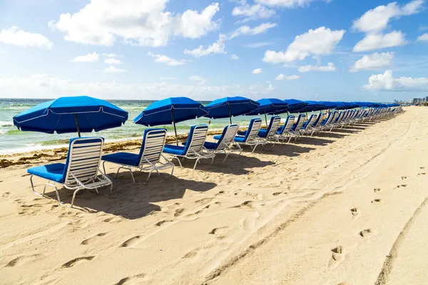 Umbrellas and empty beach couches at the beach — Stock Photo, Image