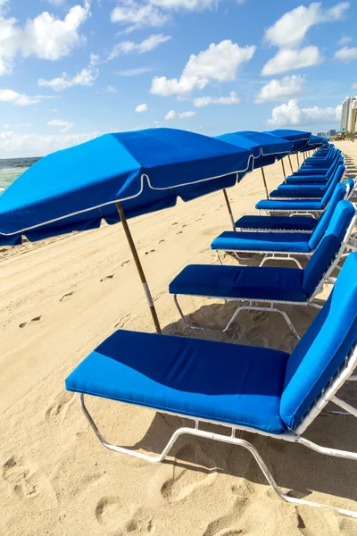 Umbrellas and empty beach couches at the beach — Stock Photo, Image