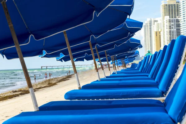 Umbrellas and empty beach couches at the beach — Stock Photo, Image