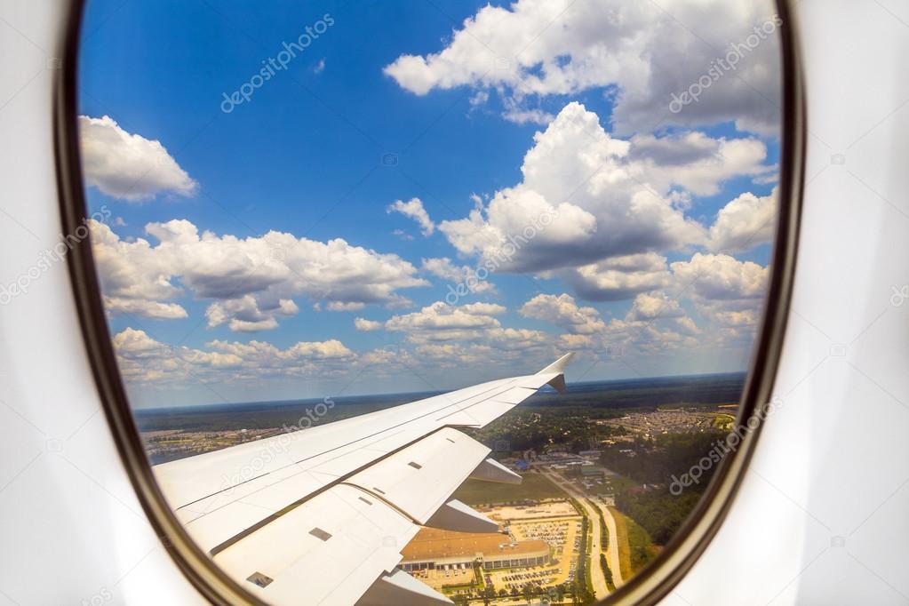 lookout of aircraft window to landscape while landing