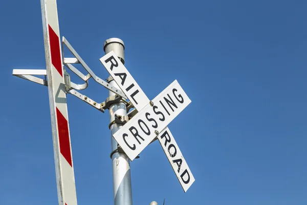 Señal de cruce de advertencia de ferrocarril bajo el cielo azul —  Fotos de Stock