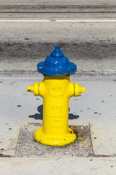 Желтый гидрант на тротуаре — стоковое фото