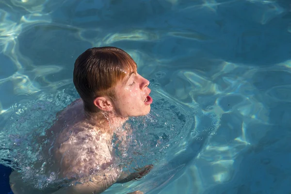 Menino gosta de nadar na piscina — Fotografia de Stock