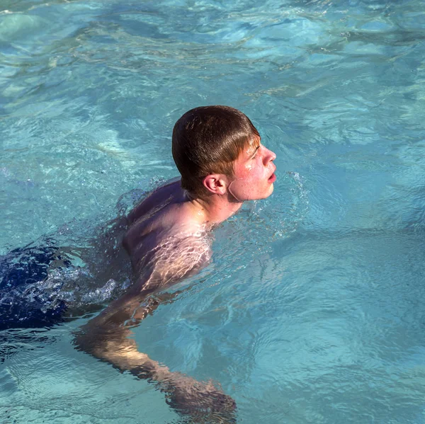 Menino gosta de nadar na piscina — Fotografia de Stock