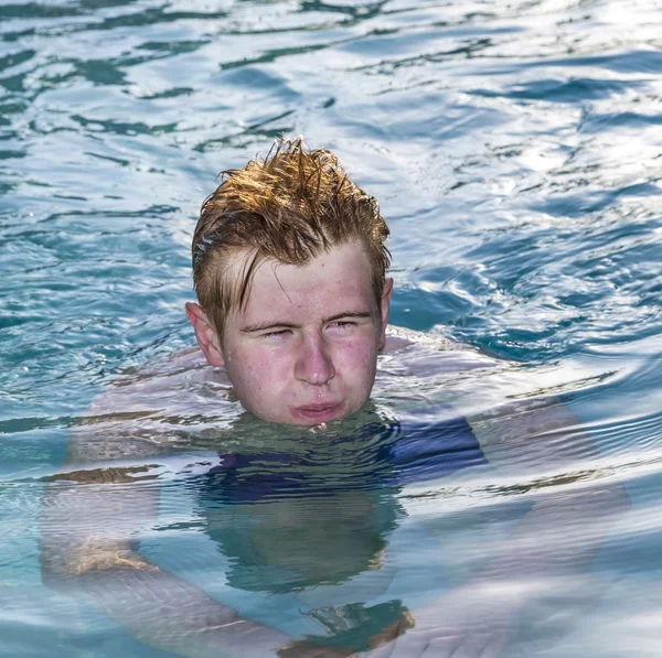 Menino gosta de nadar na piscina — Fotografia de Stock