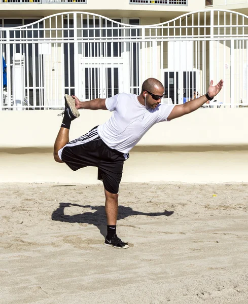 Man voert zijn oefeningen van de yoga op het strand — Stockfoto