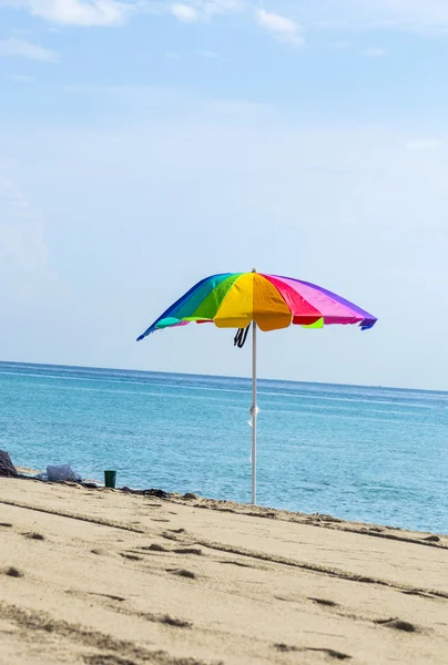 Guarda-chuva de praia colorido na areia — Fotografia de Stock