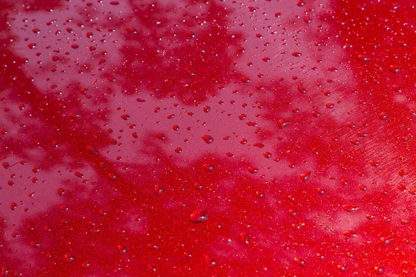 Drop of water at a red color metal of a car — Stock Photo, Image