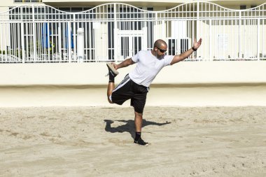 adam onun yoga egzersizleri sahilde gerçekleştirir