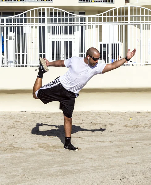 男子执行他在海滩的瑜伽练习 — 图库照片