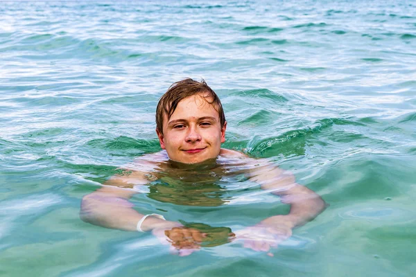 Tiener geniet zwemmen in de Oceaan — Stockfoto
