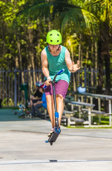 Boy has fun riding his push scooter at the skate park — Stock Photo, Image