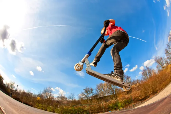 Boy jumping with a scooter over a funbox — Zdjęcie stockowe