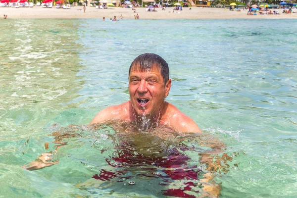 Mann hat Spaß beim Schwimmen im Ozean — Stockfoto