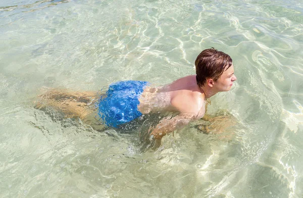 Schöner Teenager hat Spaß beim Schwimmen im Ozean — Stockfoto