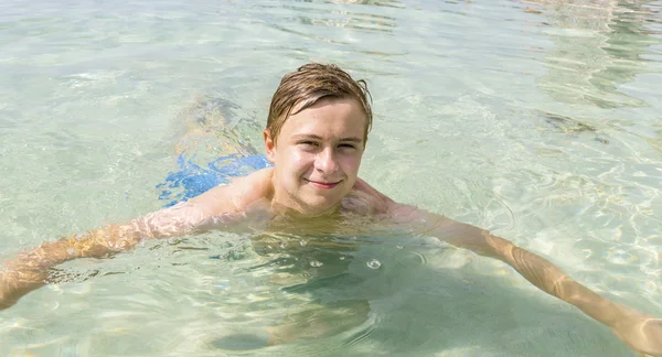 Bonito adolescente se diverte nadando no oceano — Fotografia de Stock