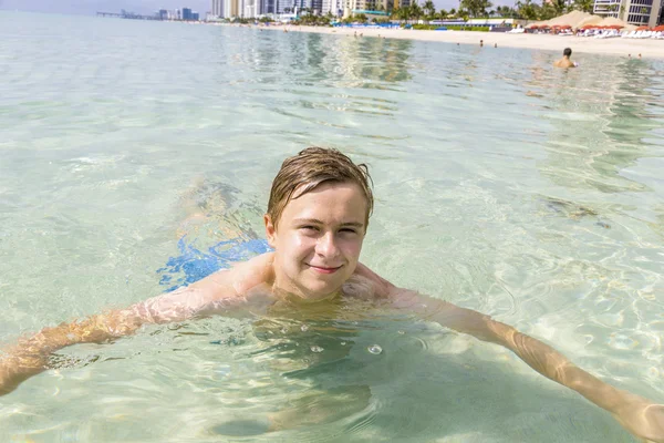 Bonito adolescente se diverte nadando no oceano — Fotografia de Stock