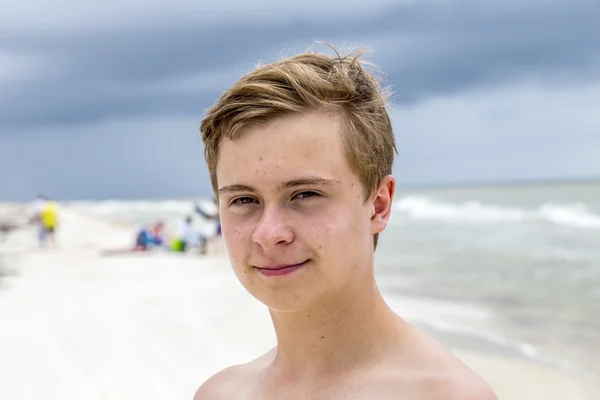 Junger glücklicher Junge sieht gut aus am Strand — Stockfoto