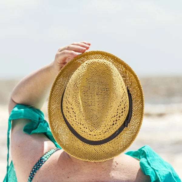 Kvinnan har sitter på stranden och ser till havet — Stockfoto