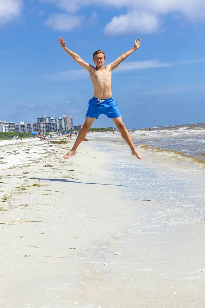 Menino salta no ar na praia — Fotografia de Stock