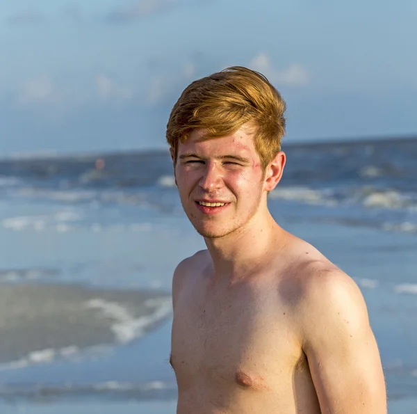 Knappe vertrouwen tiener in de zonsondergang op het strand — Stockfoto