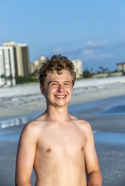 Knappe vertrouwen tiener in de zonsondergang op het strand — Stockfoto