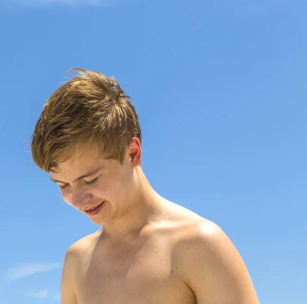 Glücklicher Junge nach dem Schwimmen am sonnigen Strand — Stockfoto