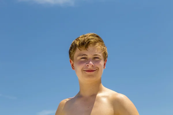 太陽が降り注ぐビーチでの水泳の後の幸せな少年 — ストック写真