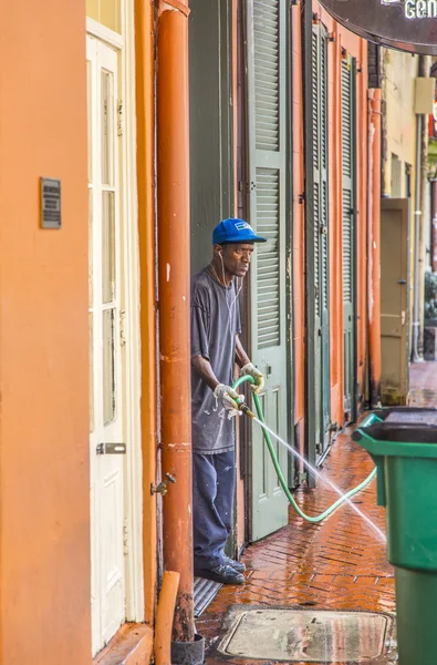 Man rengör gångvägen på morgonen i new orleans — Stockfoto