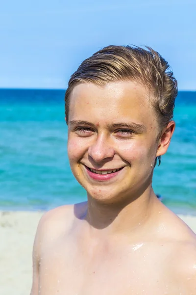 Guapo confiado adolescente en la playa con el pelo mojado después swi —  Fotos de Stock