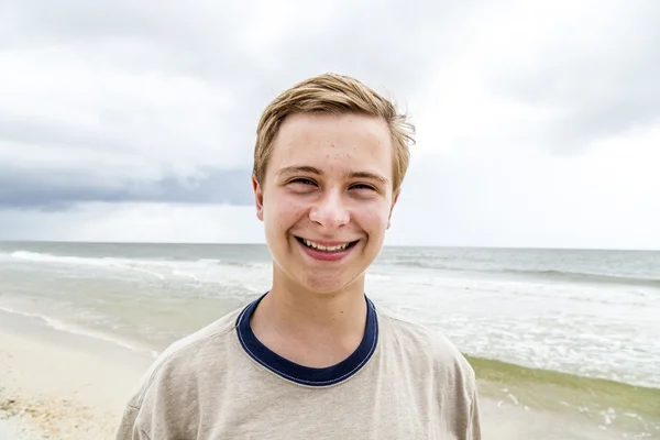 Knappe lachende jongen op het strand — Stockfoto