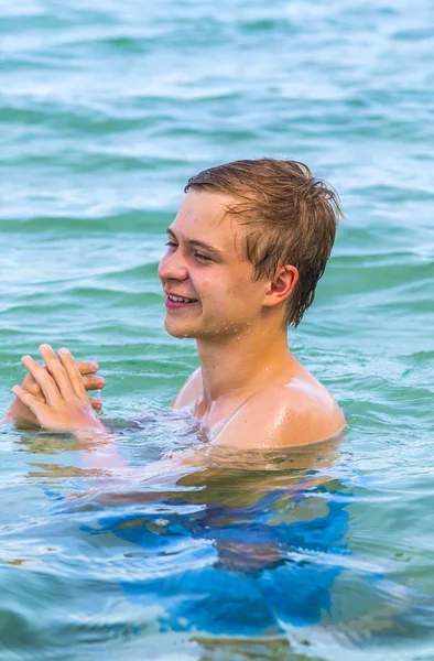 Tiener geniet zwemmen in de Oceaan en laughes — Stockfoto