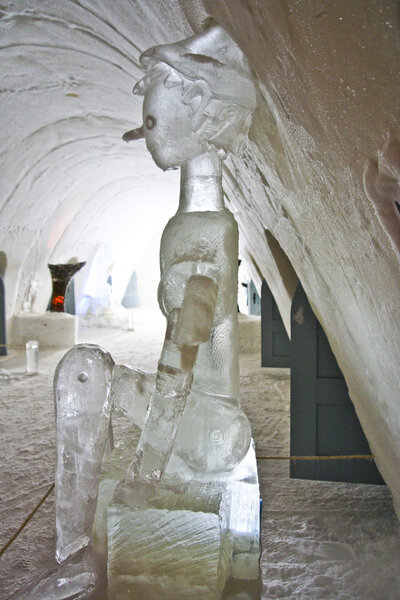 Colorfully illuminated corridor in an ice hotel with figure of p