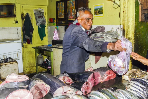 Человек продает свежую рыбу в своем магазине — стоковое фото