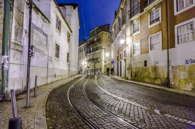 streetcar rails in the old part of Lisbon by night clipart