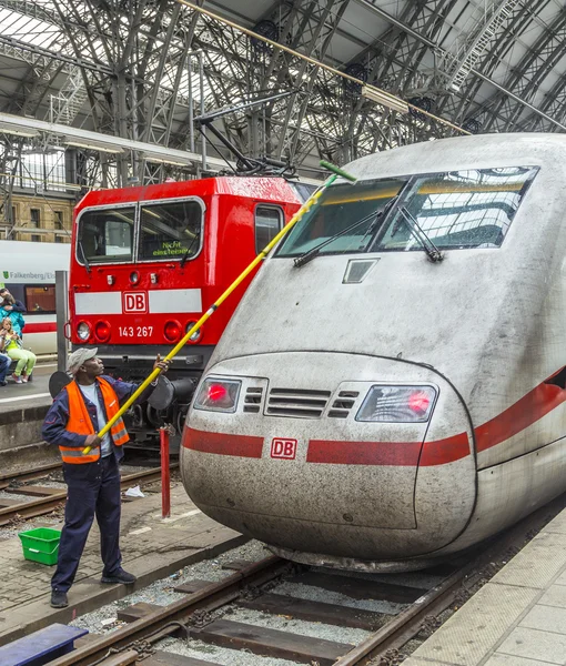 Trabalhador limpa o pára-brisas dianteiro de um trem de alta velocidade — Fotografia de Stock