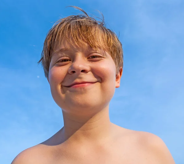 Gelukkig glimlachen jong jongen met achtergrond blauw hemel — Stockfoto