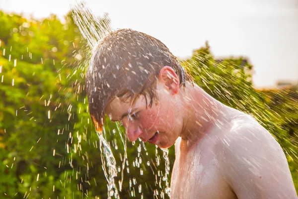 Fiú van egy zuhanyzó, a strandon — Stock Fotó