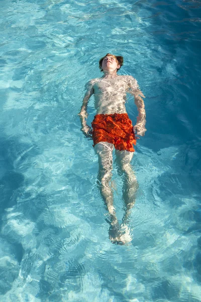 Barnet simmar ryggsim i poolen — Stockfoto