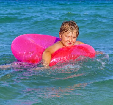 Çocuk bir yüzmenin halka eğlenceli ocea vardır.