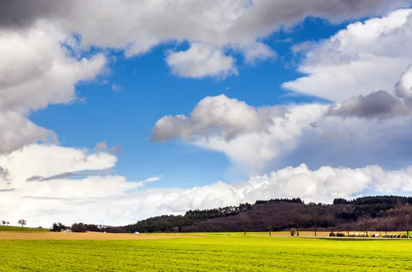 Dunkle Wolken über Feldern im Frühling — Stockfoto