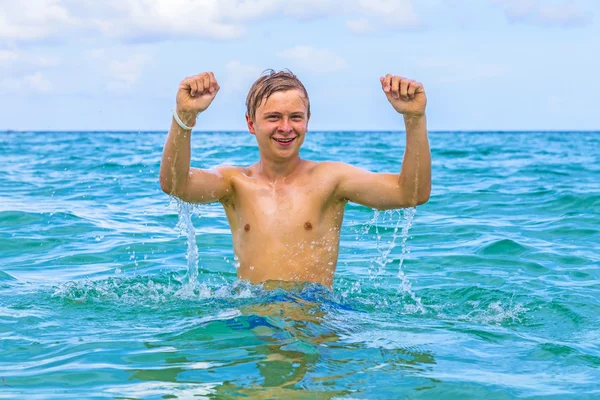 Jongen springt uit het water — Stockfoto