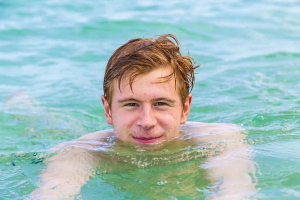 Teenage boy enjoys swimming in the ocean — Stock Photo, Image