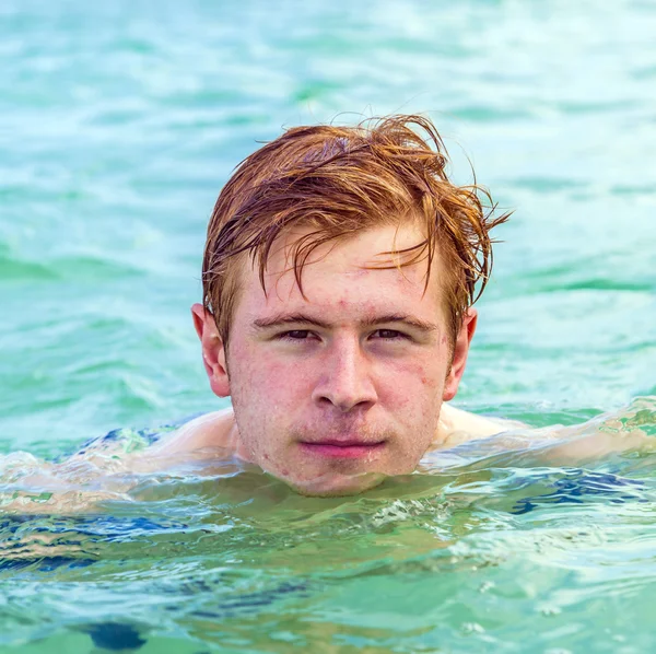 Adolescente ragazzo gode di nuotare nell'oceano — Foto Stock