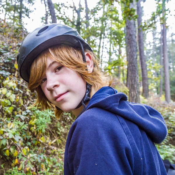Мальчик-подросток в лесу с велосипедным шлемом — стоковое фото
