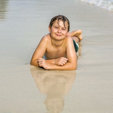 mutlu çocuk sahilde yalan söylüyor