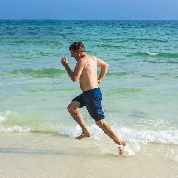 Man runs along the beautiful beach — Stock Photo, Image